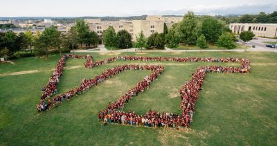 students on drillfield forming the vt logo